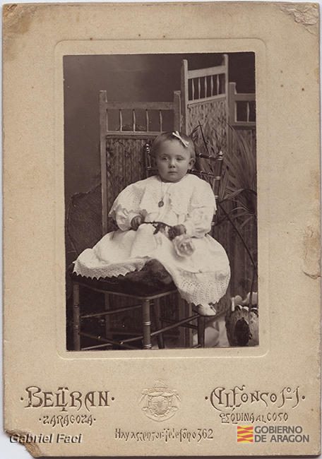 Retrato de una niña pequeña sentada en una silla. Beltrán